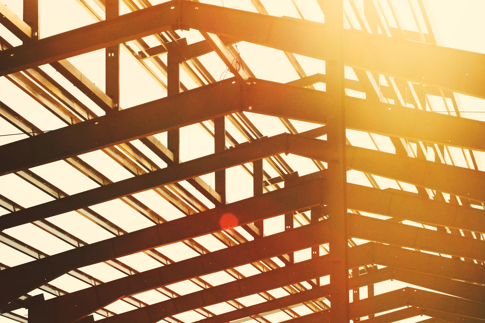 Steel roof structure lit by low golden sun