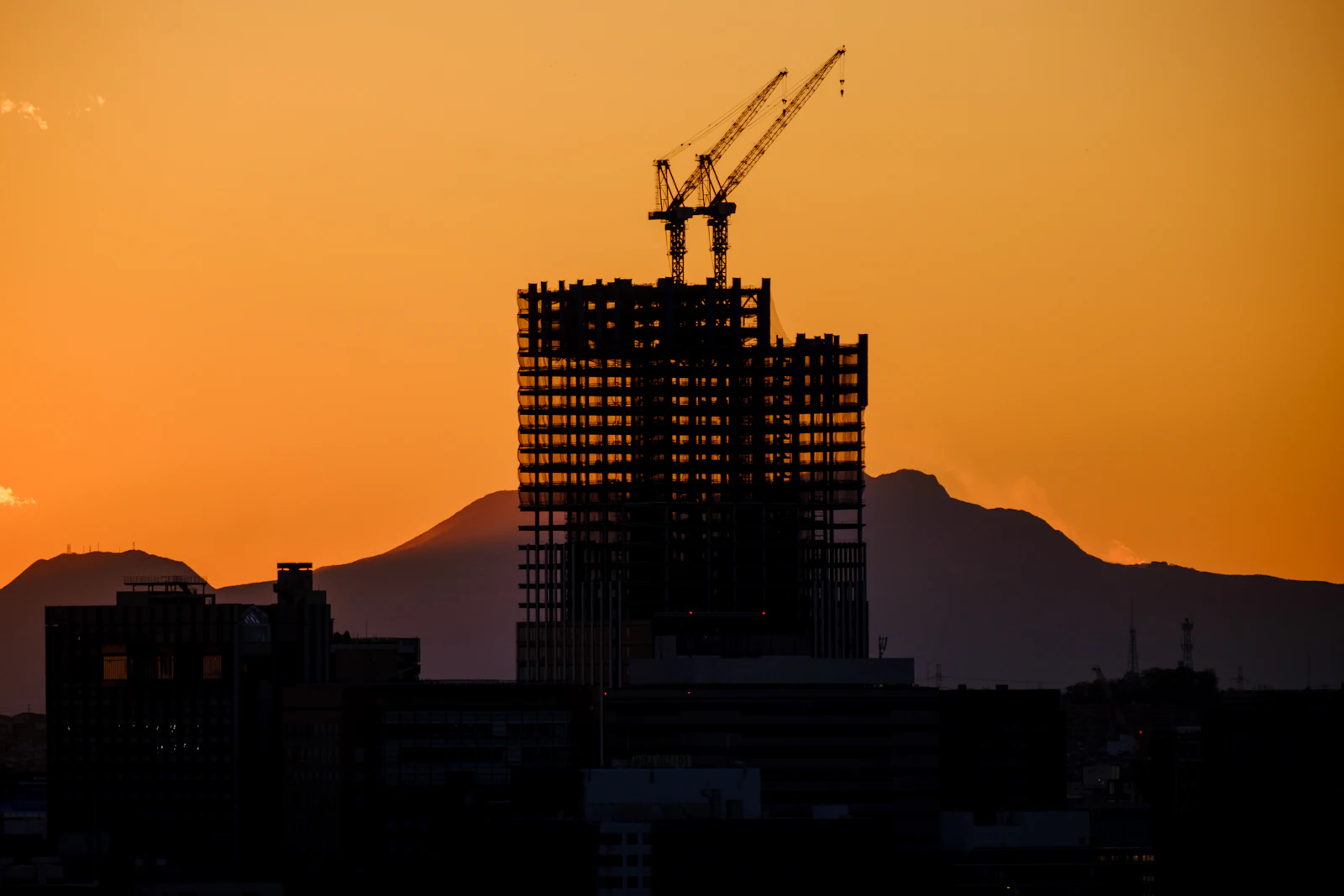 High-rise under construction silhouetted at sunset